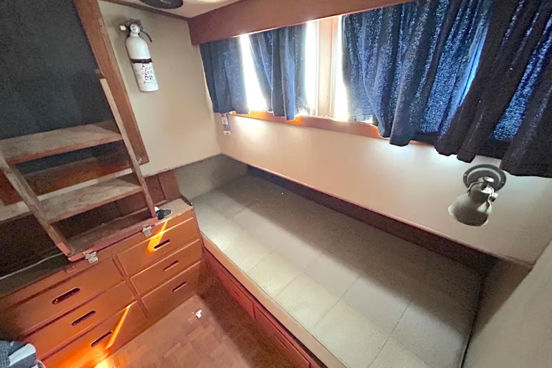 Slide: The Image of Interior cabin of 1988 Grand Banks 36 Classic with bed, storage, and window curtains. - 34