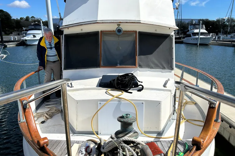 Slide: The Image of 1988 Grand Banks 36 Classic yacht docked at marina with person on deck. - 4