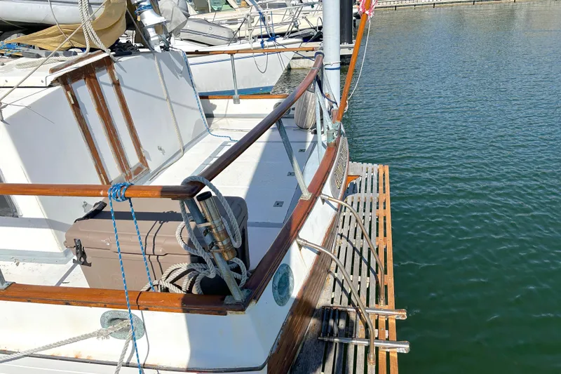 Slide: The Image of 1988 Grand Banks 36 Classic yacht docked, featuring wooden railings and deck details. - 6