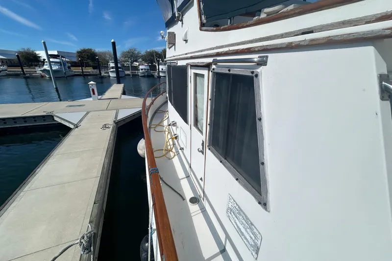 Slide: The Image of 1988 Grand Banks 36 Classic yacht docked at marina under clear blue sky. - 7