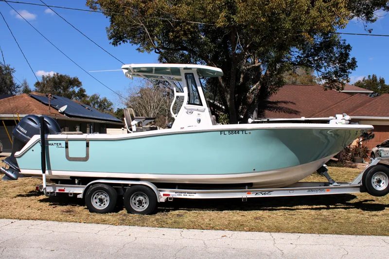 Slide: The Image of 2022 Tidewater 272 CC Adventure boat on trailer, parked outdoors. - 1