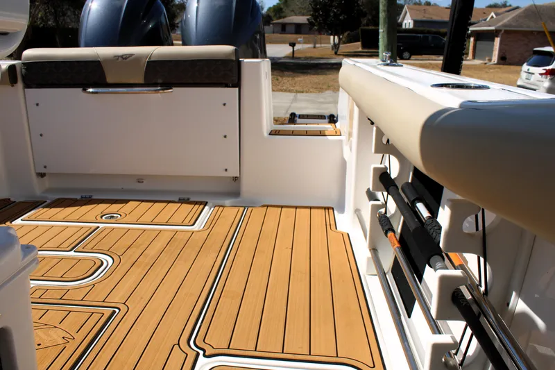 Slide: The Image of 2022 Tidewater 272 CC Adventure boat interior with teak flooring and fishing rod holders. - 15
