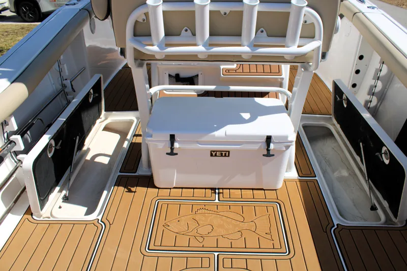 Slide: The Image of 2022 Tidewater 272 CC Adventure boat interior with Yeti cooler and rod holders. - 16