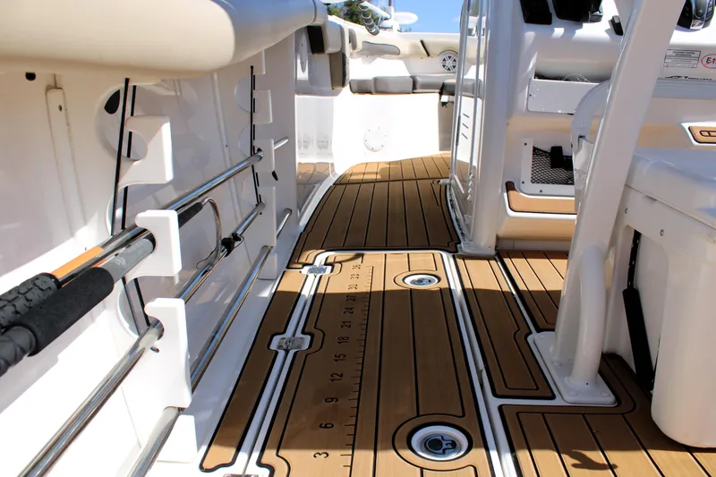Slide: The Image of 2022 Tidewater 272 CC Adventure boat interior with teak flooring and fishing rod holders. - 17