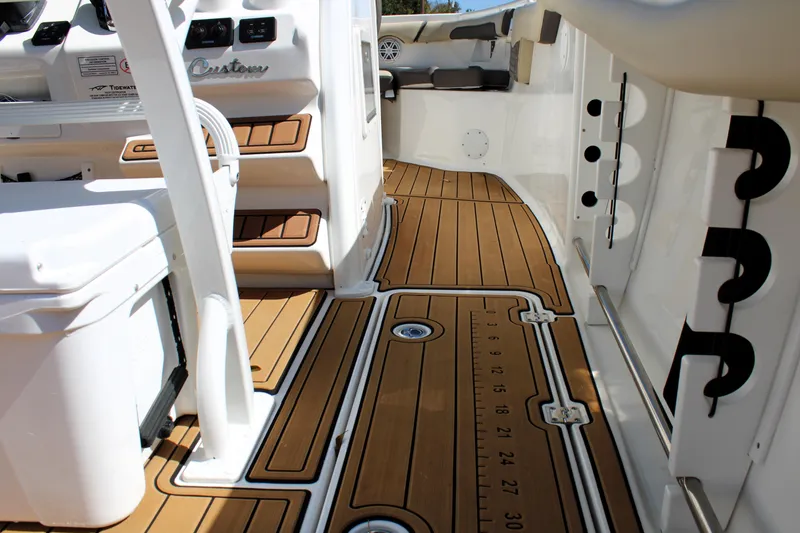 Slide: The Image of 2022 Tidewater 272 CC Adventure boat interior with teak flooring and modern design features. - 18