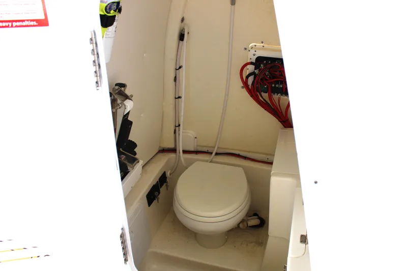 Slide: The Image of 2022 Tidewater 272 CC Adventure boat interior with compact marine toilet. - 19