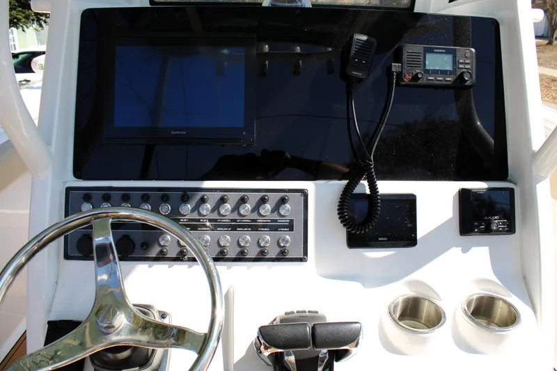 Slide: The Image of 2022 Tidewater 272 CC Adventure boat dashboard with steering wheel and electronic controls. - 21