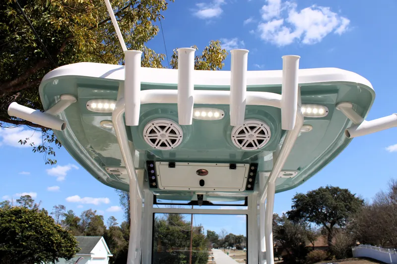 Slide: The Image of 2022 Tidewater 272 CC Adventure boat with rod holders and speakers under a clear blue sky. - 26