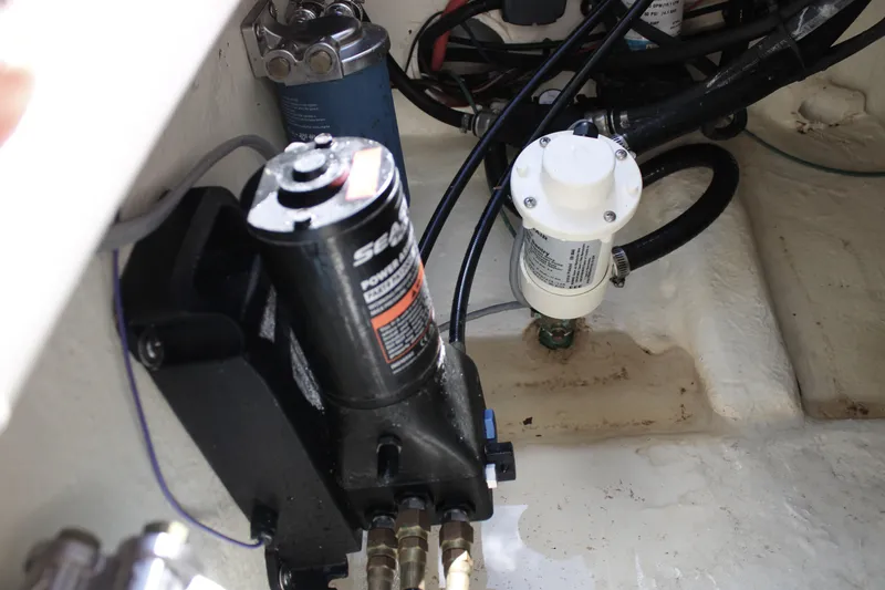 Slide: The Image of 2022 Tidewater 272 CC Adventure boat engine compartment with hydraulic and fuel components. - 28