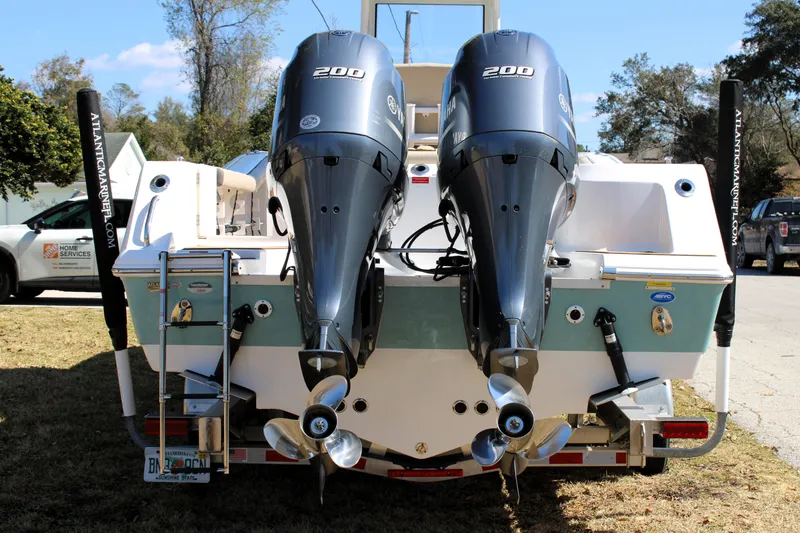 Slide: The Image of 2022 Tidewater 272 CC Adventure boat with dual Yamaha 200 engines, parked outdoors. - 3