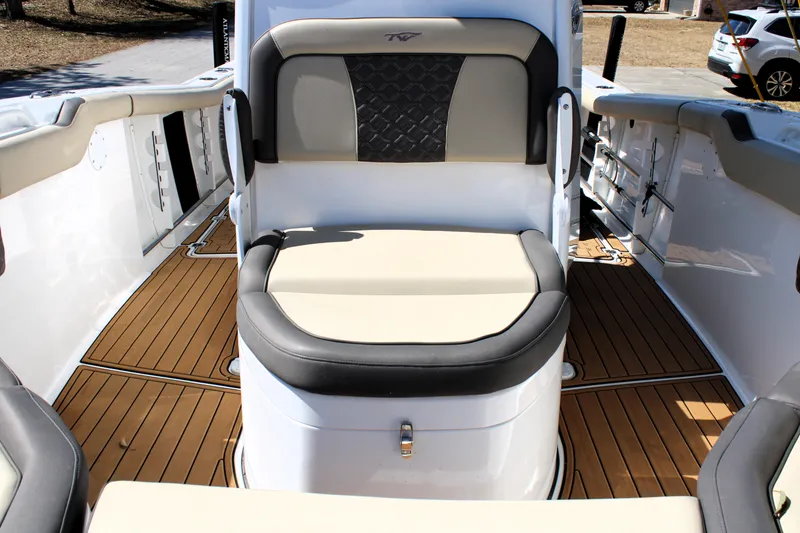 Slide: The Image of 2022 Tidewater 272 CC Adventure boat interior with cushioned seating and teak flooring. - 32