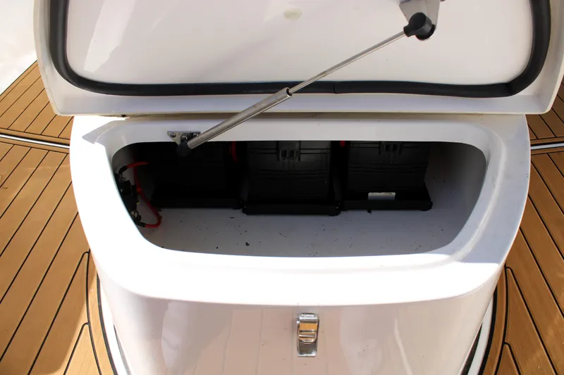 Slide: The Image of Open storage compartment on 2022 Tidewater 272 CC Adventure boat, revealing battery setup. - 36