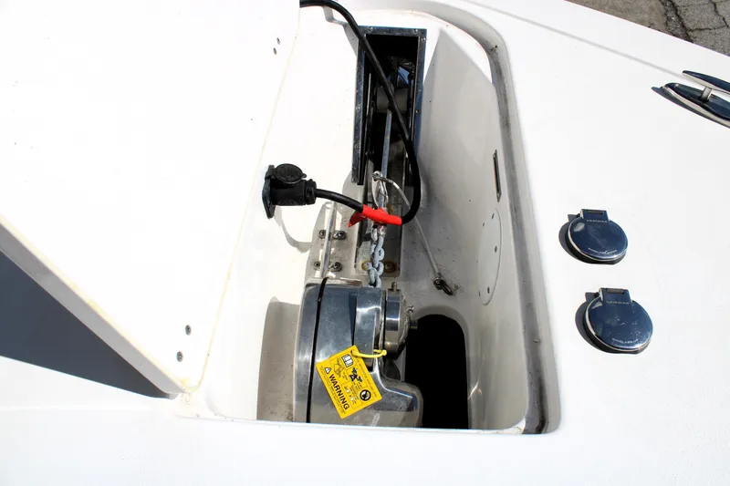 Slide: The Image of 2022 Tidewater 272 CC Adventure boat anchor compartment with visible wiring and warning label. - 40
