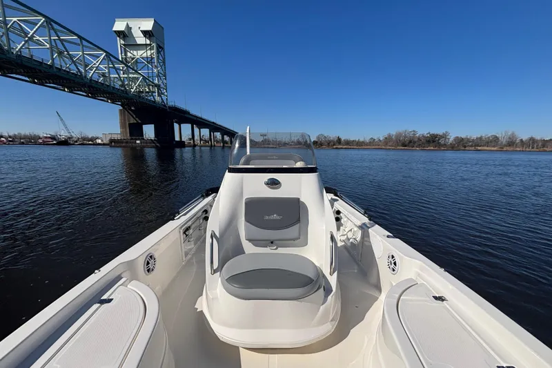 Slide: The Image of 2023 NauticStar 215 XTS boat on water near a bridge under clear blue sky. - 3