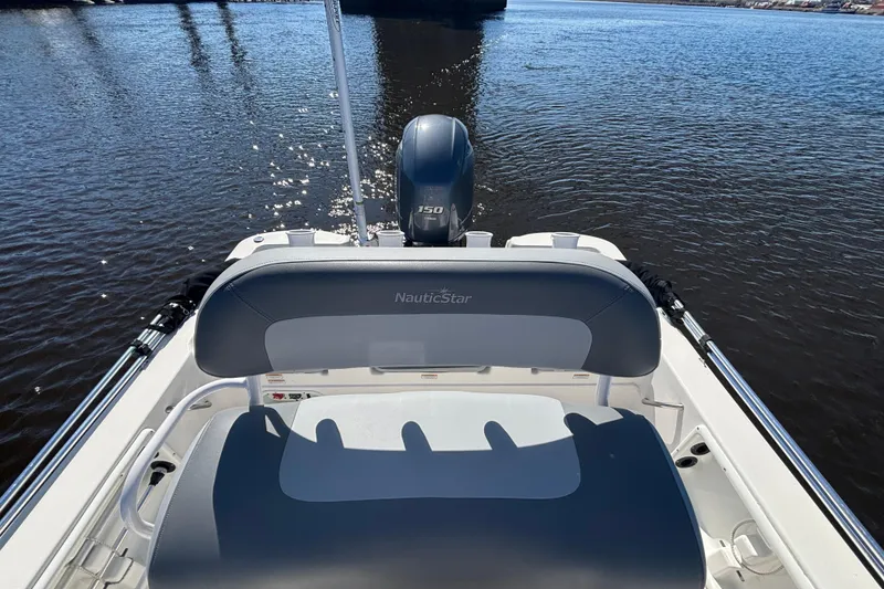 Slide: The Image of 2023 NauticStar 215 XTS boat on water, featuring sleek seating and powerful outboard motor. - 5