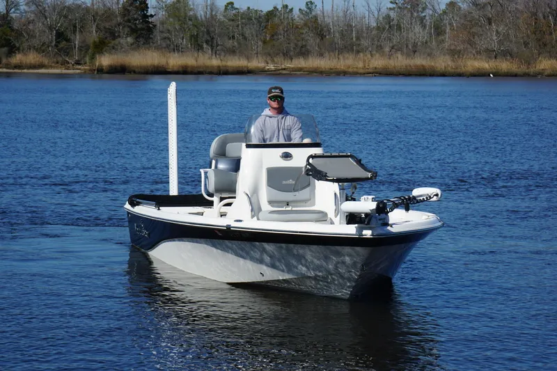 Slide: The Image of 2023 NauticStar 215 XTS boat on calm water with a person at the helm. - 6