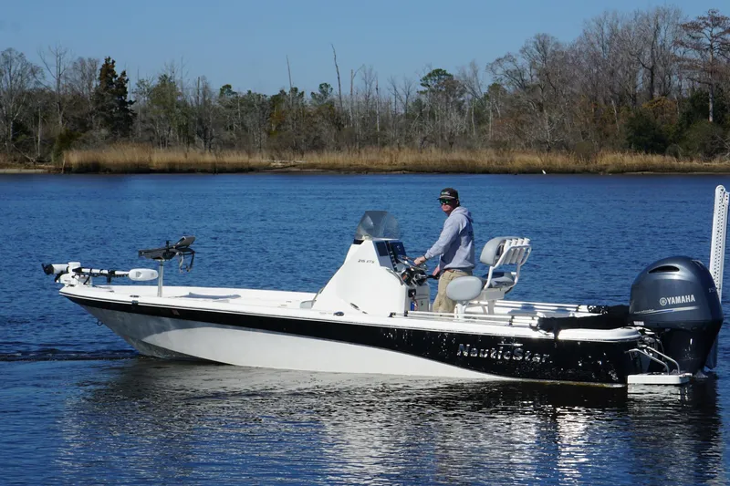 Slide: The Image of 2023 NauticStar 215 XTS boat on a calm lake with a Yamaha engine. - 8