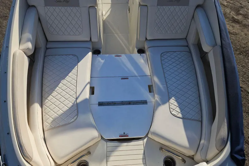 Slide: The Image of 2009 Searay 260 boat interior with white quilted seating and storage compartments. - 6