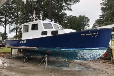 Slide: The Image of 1979 Bruno & Stillman 35 Downeast Cruiser, blue hull, on land with trees in background. - 1