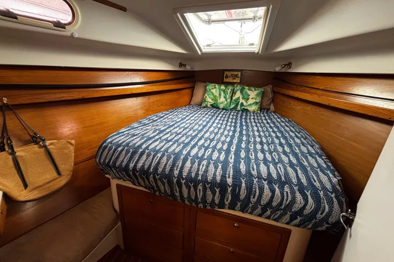 Slide: The Image of Cozy cabin interior of 2005 Catalina Morgan 440 sailboat with patterned bedding and wooden accents. - 10