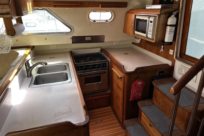Slide: The Image of 2005 Catalina Morgan 440 yacht kitchen with stove, sink, and microwave. - 25