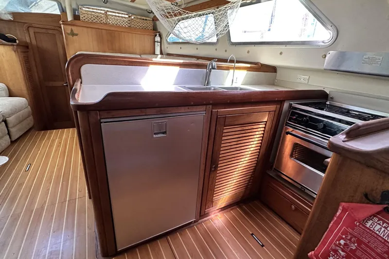 Slide: The Image of 2005 Catalina Morgan 440 yacht kitchen with wood cabinetry, stainless appliances, and ample counter space. - 28