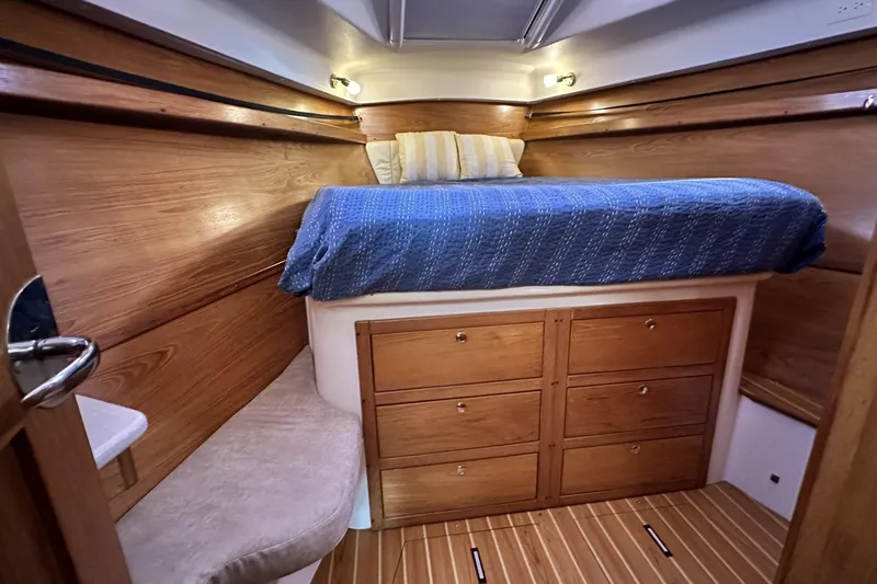 Slide: The Image of Cozy cabin interior of 2005 Catalina Morgan 440 sailboat with wooden drawers and bed. - 33