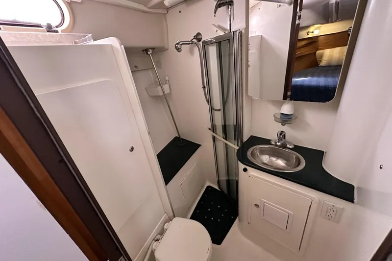 Slide: The Image of Compact bathroom in a 2005 Catalina Morgan 440 yacht, featuring shower, sink, and mirror. - 36