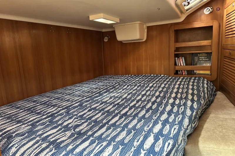 Slide: The Image of Cozy cabin interior of 2005 Catalina Morgan 440 with patterned bedding and wooden shelves. - 37