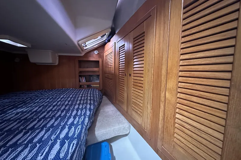 Slide: The Image of Cozy cabin interior of 2005 Catalina Morgan 440 sailboat with wooden paneling and patterned bedding. - 38
