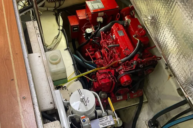 Slide: The Image of Engine compartment of a 2005 Catalina Morgan 440 sailboat, featuring a red marine engine. - 44