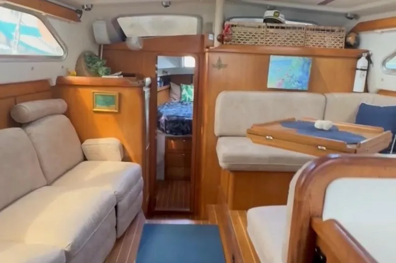 Slide: The Image of Interior of a 2005 Catalina Morgan 440 sailboat, featuring cozy seating and wooden accents. - 5