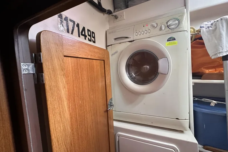 Slide: The Image of Laundry area inside a 2005 Catalina Morgan 440 yacht, featuring a compact washing machine. - 52