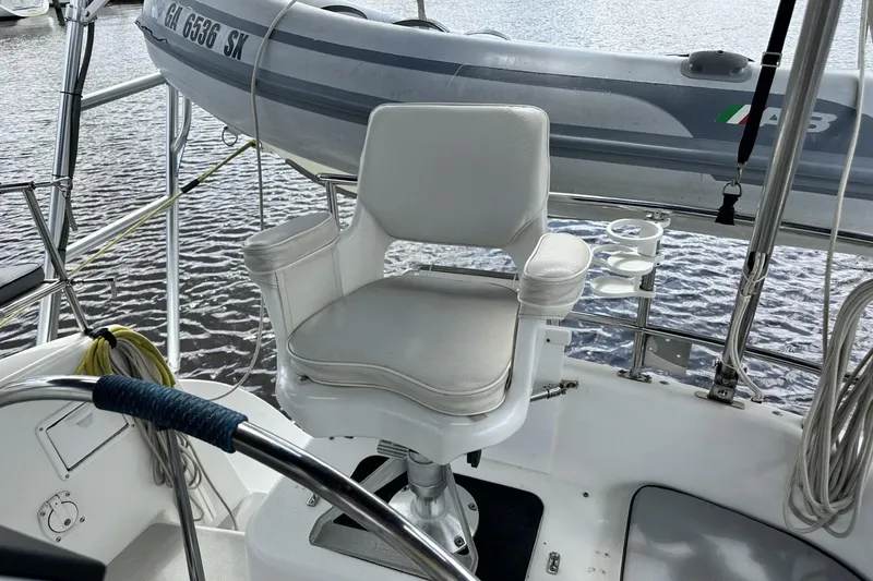 Slide: The Image of Captain's chair on 2005 Catalina Morgan 440 sailboat with dinghy in background. - 60
