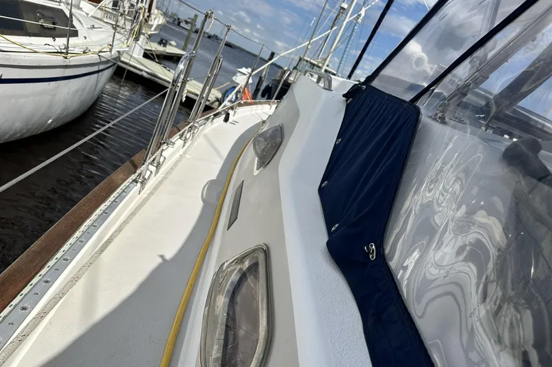 Slide: The Image of 2005 Catalina Morgan 440 sailboat docked, showcasing deck and railing details. - 63