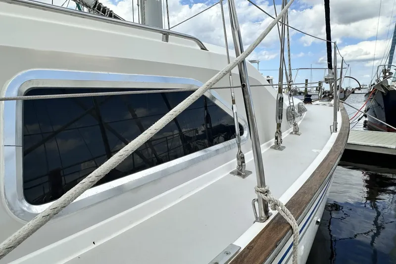 Slide: The Image of 2005 Catalina Morgan 440 sailboat deck with ropes and window, docked at marina. - 64