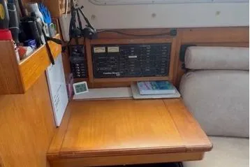 Slide: The Image of Navigation station inside a 2005 Catalina Morgan 440 sailboat, featuring a wooden desk and control panel. - 7