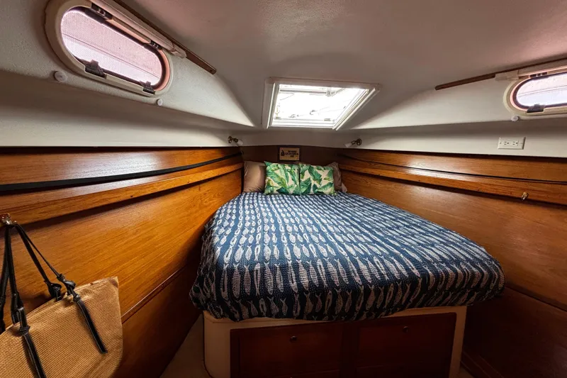 Slide: The Image of Cozy cabin interior of 2005 Catalina Morgan 440 sailboat with wooden accents and patterned bedding. - 9