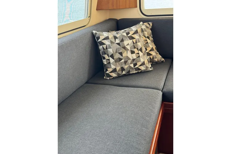 Slide: The Image of Interior of 2008 Island Packet SP Cruiser with geometric-patterned cushions on a gray sofa. - 12
