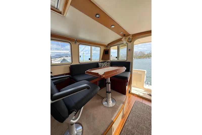 Slide: The Image of 2008 Island Packet SP Cruiser interior with seating and table, overlooking marina. - 15