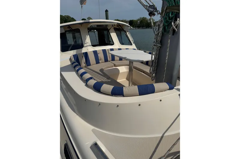Slide: The Image of 2008 Island Packet SP Cruiser with striped seating and table on deck. - 4