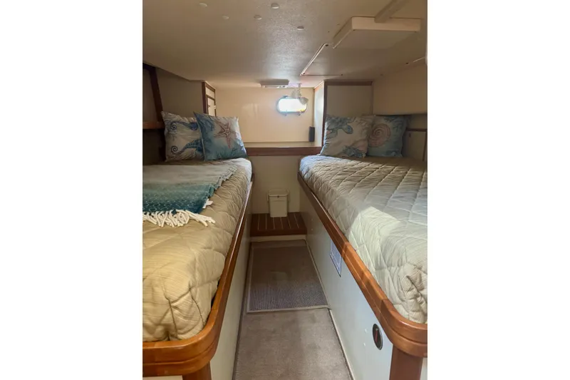 Slide: The Image of 2008 Island Packet SP Cruiser cabin with twin beds and nautical-themed decor. - 6