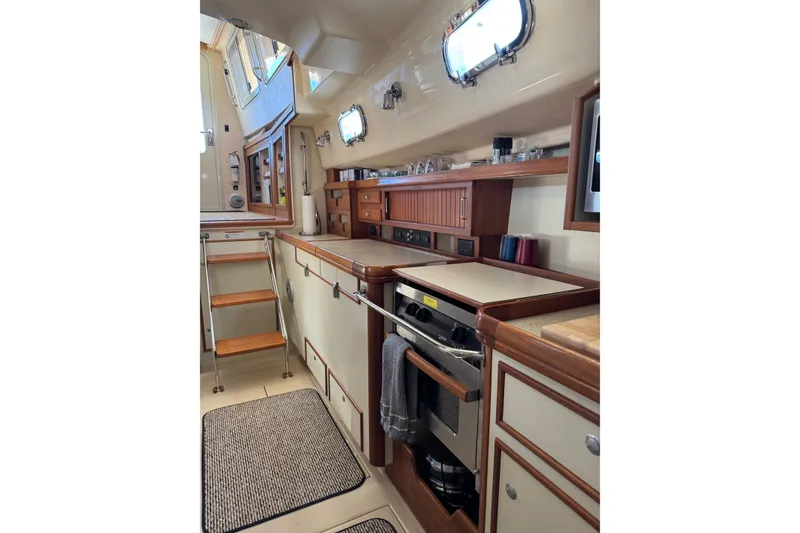 Slide: The Image of 2008 Island Packet SP Cruiser interior kitchen with wooden cabinetry and stainless steel appliances. - 9