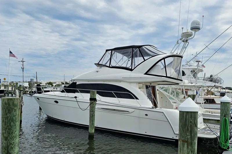 The Image of 2003 Meridian 411 Sedan yacht docked at marina under cloudy sky. - 0