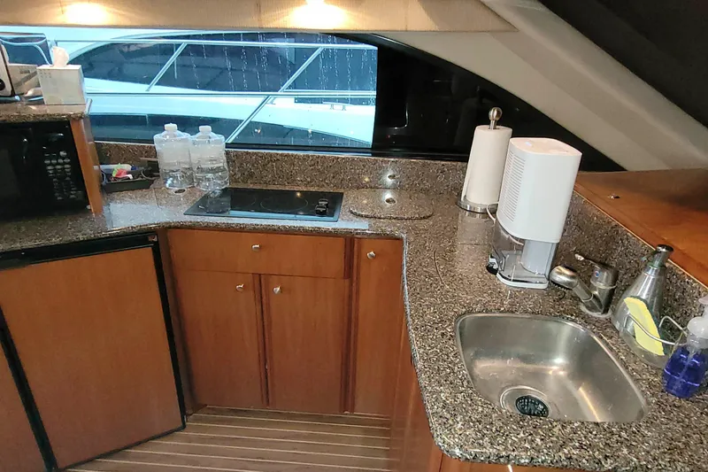 Slide: The Image of Kitchen area of a 2003 Meridian 411 Sedan yacht with granite countertops and modern appliances. - 11