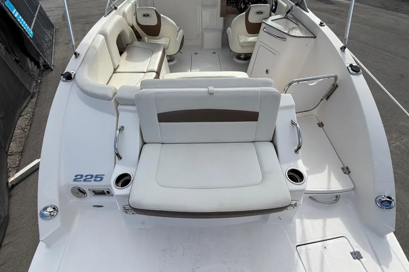 Slide: The Image of 2014 Chaparral 225 SSi boat interior with white seating and cup holders. - 10
