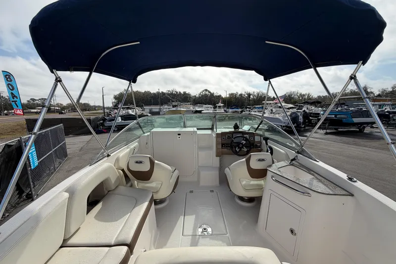 Slide: The Image of 2014 Chaparral 225 SSi boat interior with seating and steering wheel under canopy. - 14