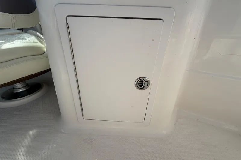 Slide: The Image of 2014 Chaparral 225 SSi boat storage compartment with secure latch. - 18