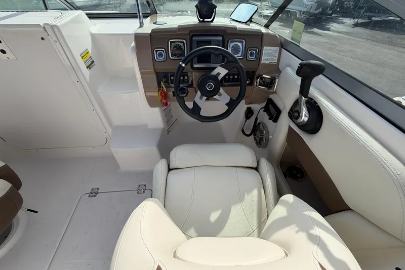 Slide: The Image of 2014 Chaparral 225 SSi boat cockpit with steering wheel and control panel. - 23