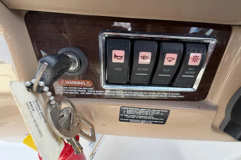Slide: The Image of Control panel of a 2014 Chaparral 225 SSi boat with ignition keys and warning labels. - 24